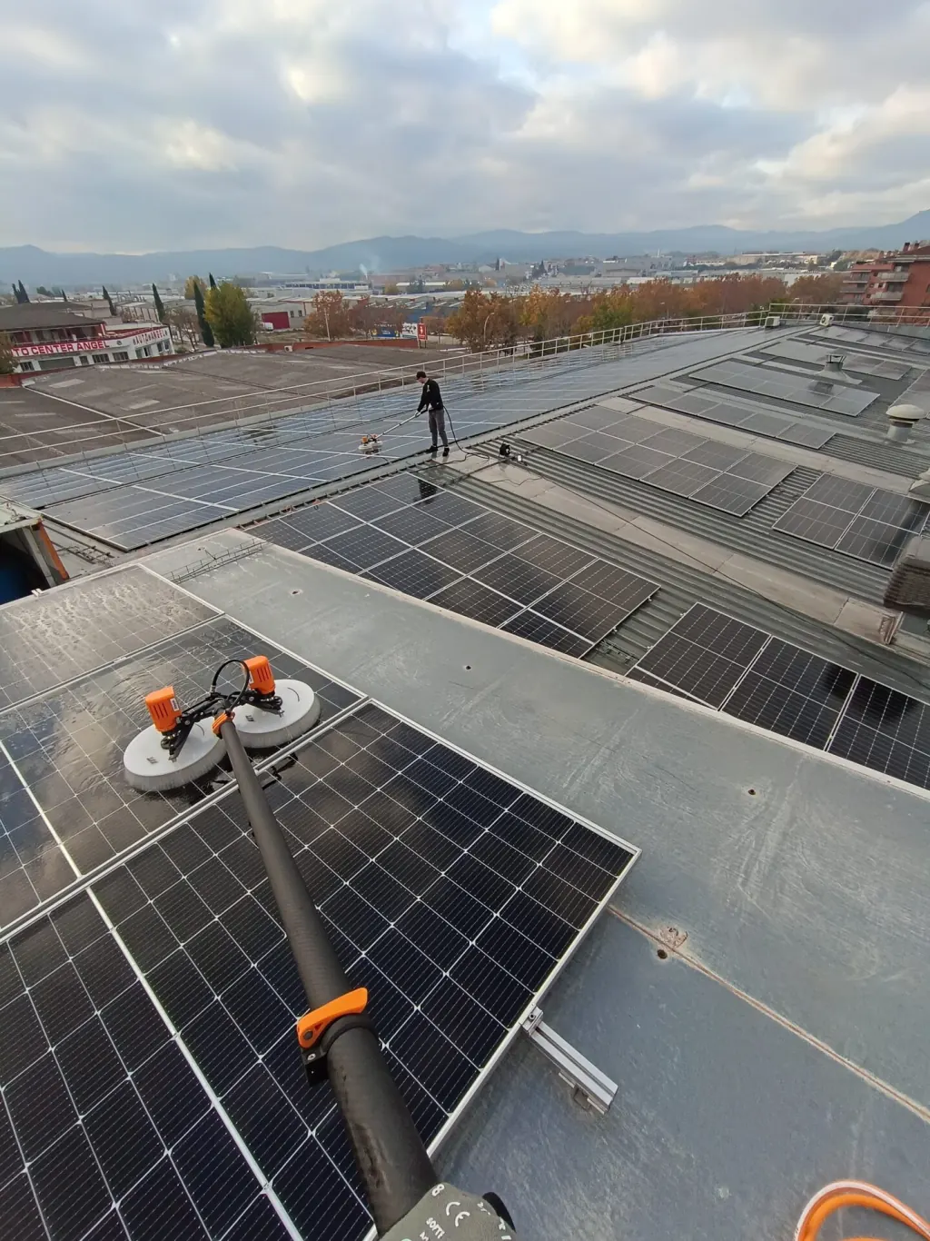 Neteja de gran coberta solar industrial amb paisatge urbà