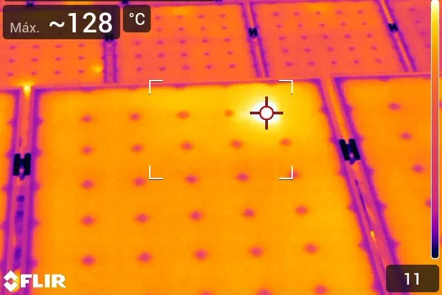 Imagen termográfica de una fila de paneles solares industriales con una anomalía térmica destacada