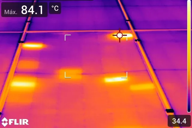 Termografía de panel solar con punto caliente localizado de 84,1 °C detectado durante una inspección